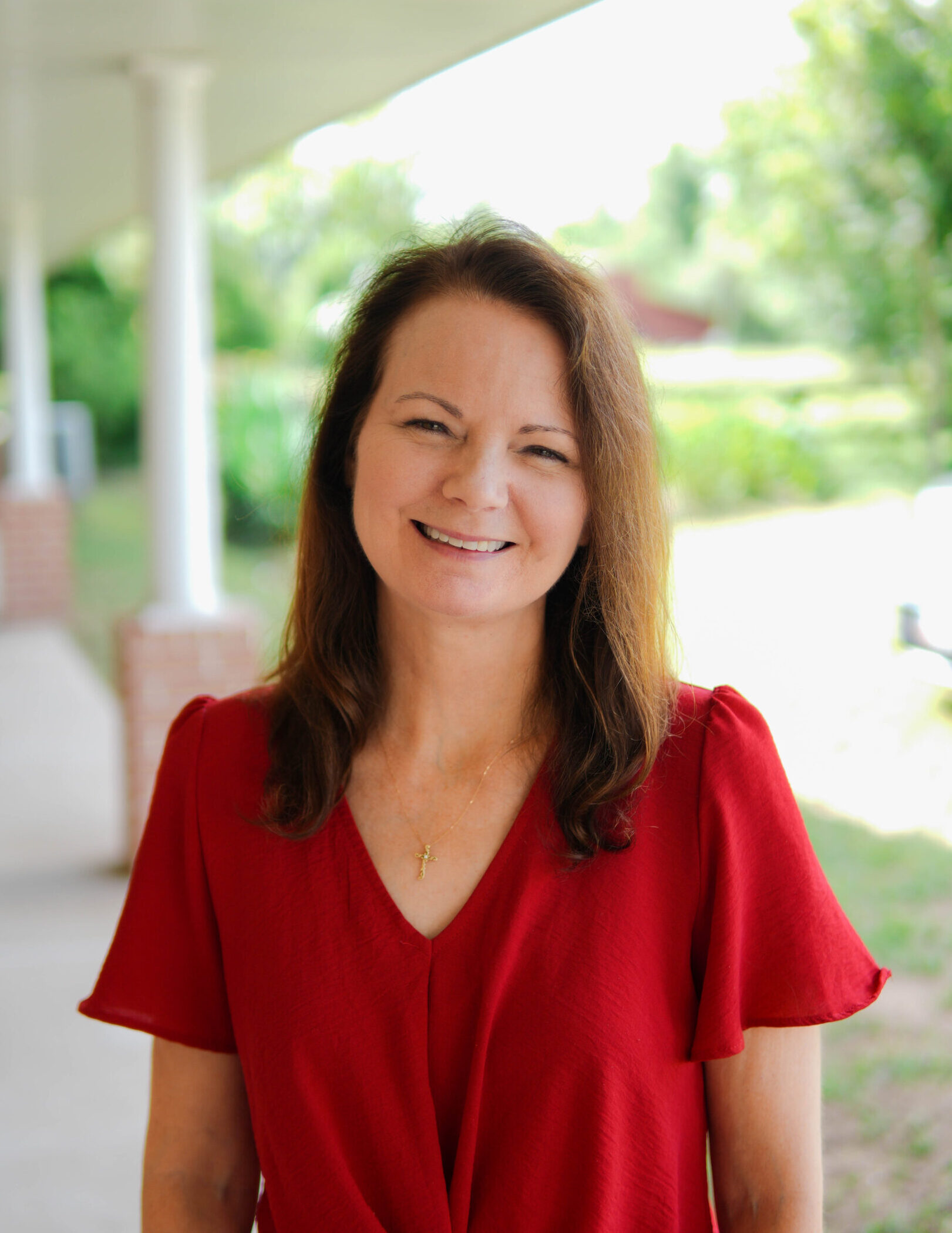 A woman in red shirt smiling for the camera.